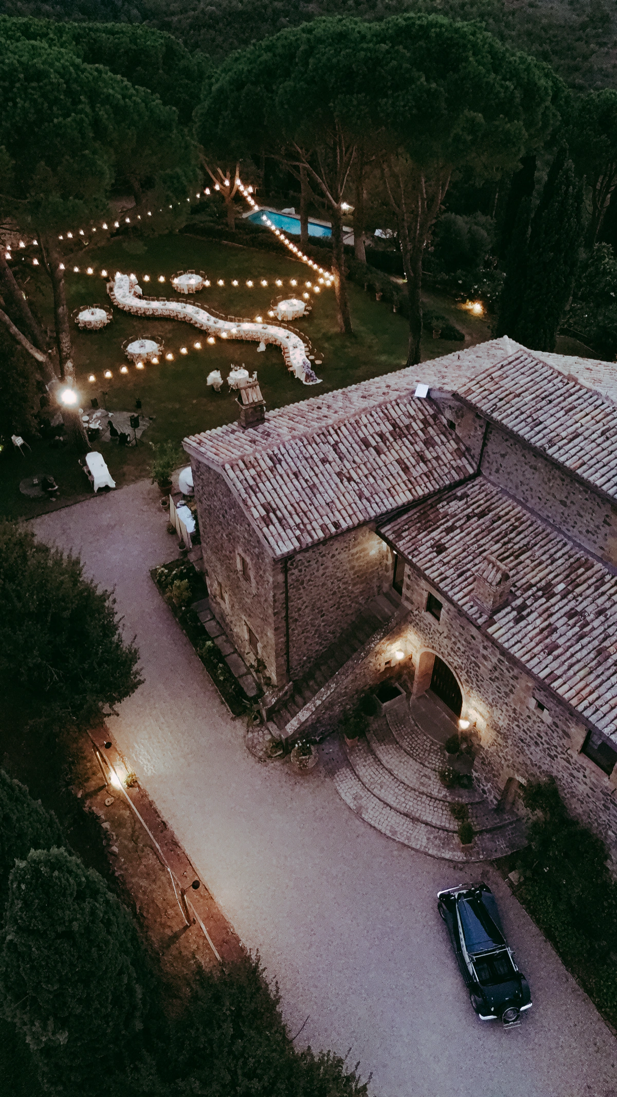 Villa in pietra vista dall'alto di sera, con il giardino illuminato per la festa — fotografia di Andrea Mortini